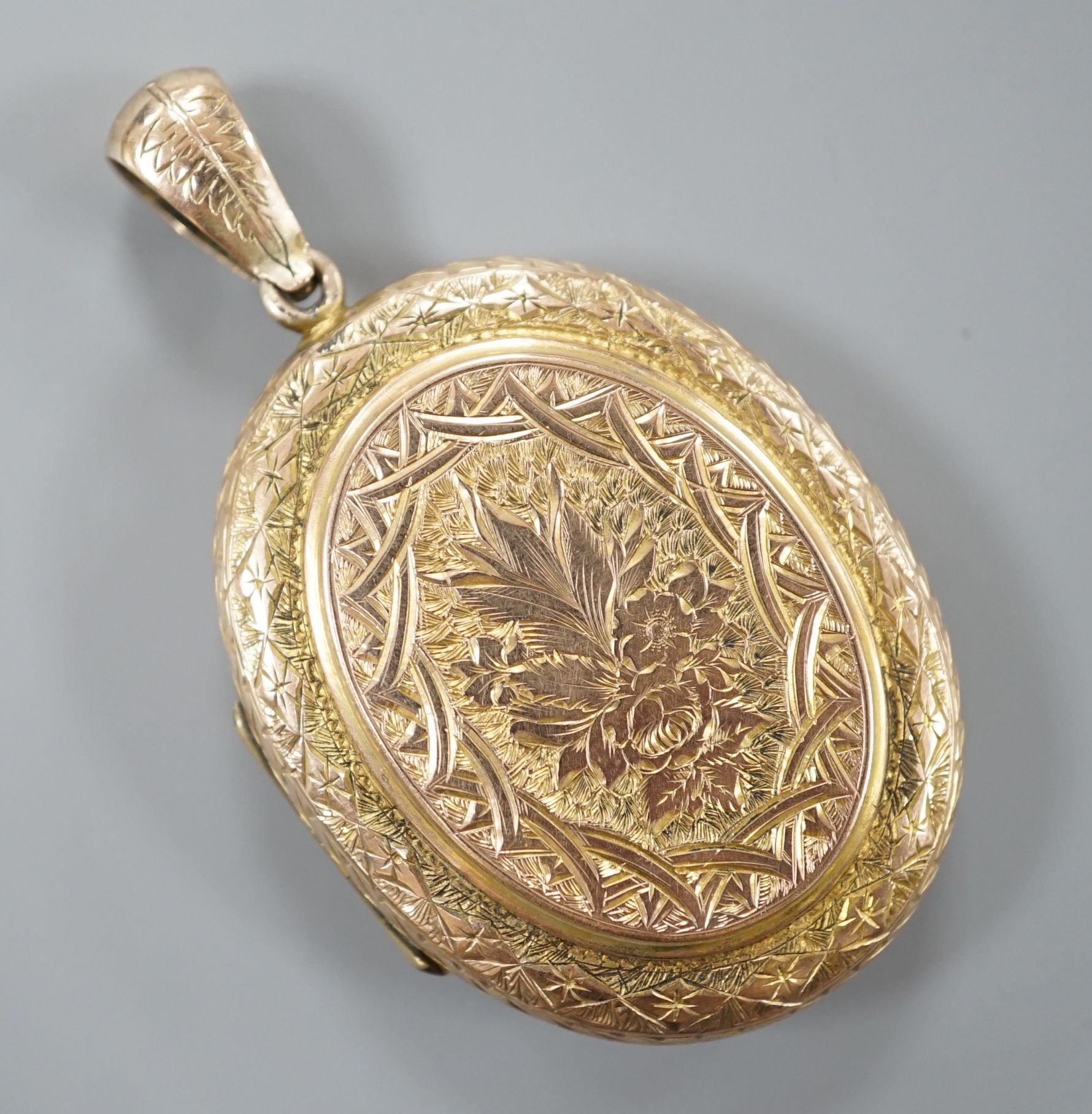 A Victorian engraved yellow metal oval locket, overall 55mm, gross weight 15.5 grams.